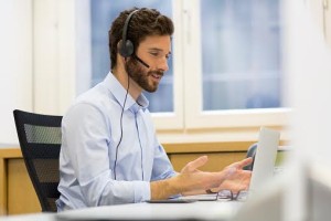 Happy Businessman in the office on the phone, headset, Skype