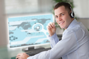 Cheerful businessman using futuristic interface hologram in bright office